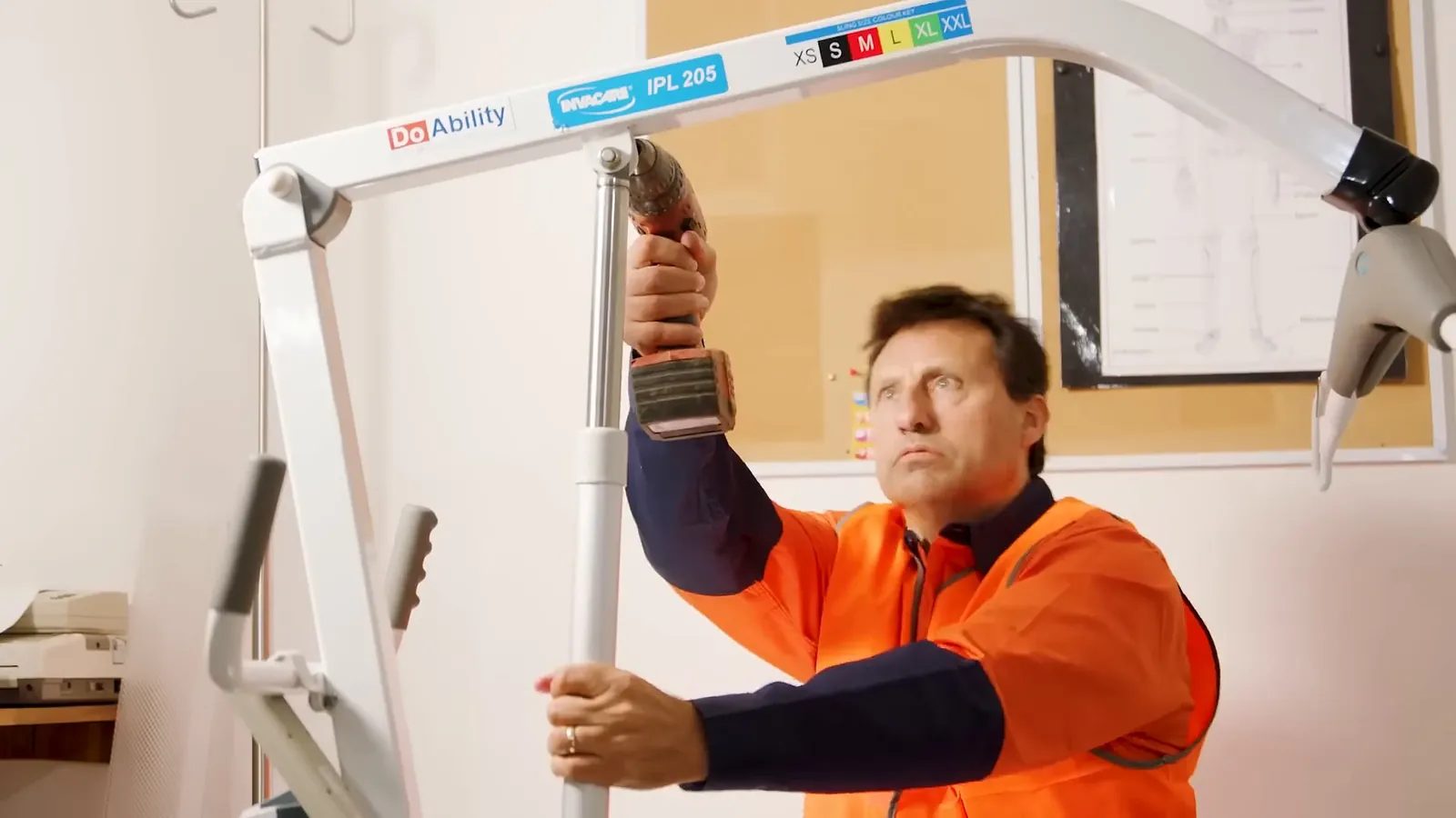 Man with a back injury reaching for a mobility hoist during rehabilitation