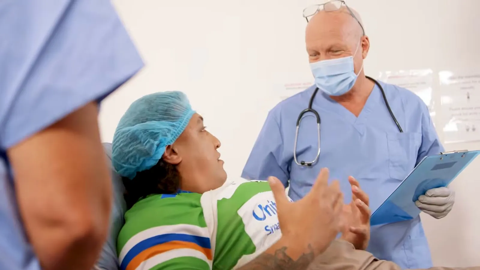 Doctor in scrubs talking to an injured patient