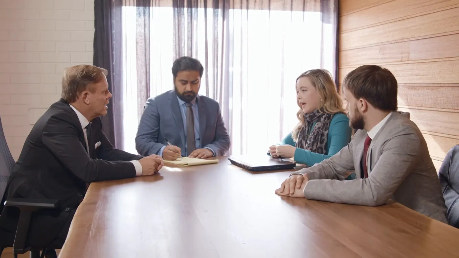 Lawyers and clients meeting at a boardroom table, injury compensation claims